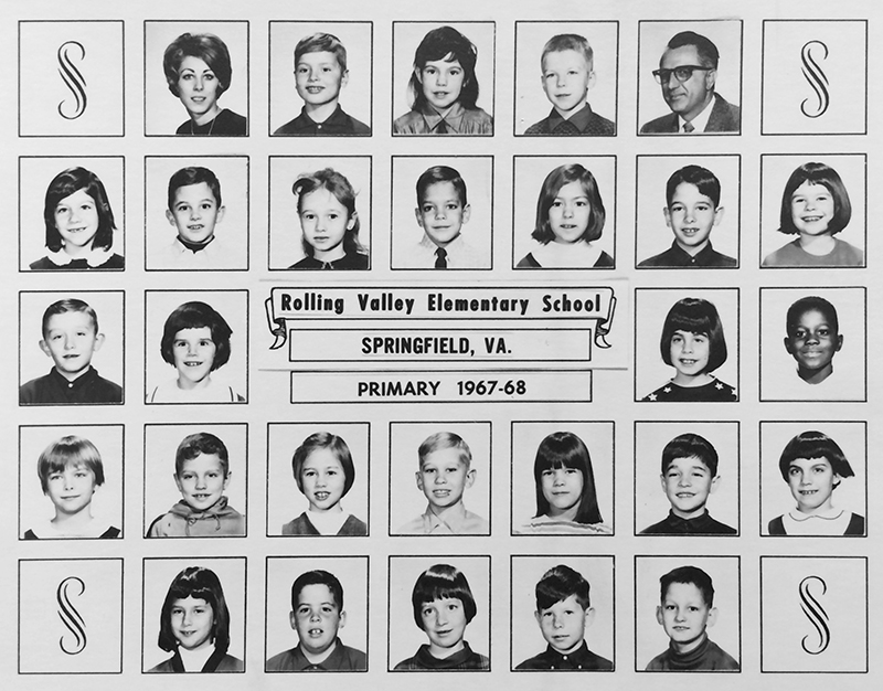 Black and white class photograph showing a primary grade classroom from Rolling Valley's first school year. Principal Mitchell and an unnamed teacher are pictured. There are 26 children pictured, an even mix of boys and girls. Almost every child pictured is Caucasian. There is one African-American boy. The diversity Rolling Valley enjoys today came about gradually from 1980 to 2000. 